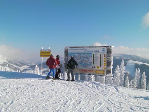 three people standing at the top of a snow covered slope at Haus Stablerkrämer in Maria Alm am Steinernen Meer