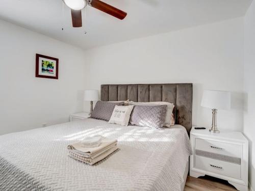 um quarto branco com uma cama e uma cabeceira em madeira em Miami Luxury 4 BD Home, Next to Wynwood & North Beach em North Miami