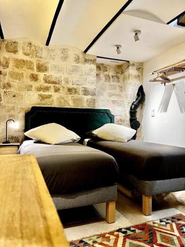 une chambre avec deux lits et un mur de briques dans l'établissement Charming apartment near Notre-Dame, à Paris