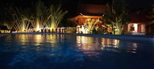 una piscina por la noche con luces en Pasak River House 