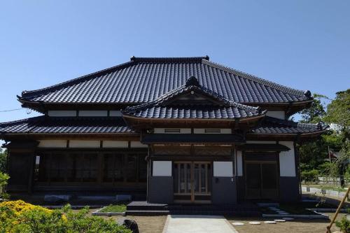 an asian style building with a roof at さくらの宿Traditional Japanese house with cherry blossoms in Hasunuma