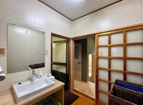 a bathroom with a sink and a mirror at さくらの宿Traditional Japanese house with cherry blossoms in Hasunuma