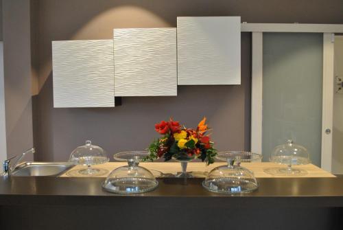 a bathroom counter with a sink and a vase of flowers at Anda e Rianda in Campi Bisenzio