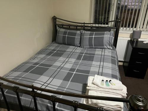 um quarto com uma cama com dois sapatos em HAMS REST PLACE - Strictly Only ONE GUEST ALLOWED IN ONE ROOM A SECOND ACCOMPANYING PERSON WILL NOT BE ALLOWED INTO THE PROPERTY em Birmingham