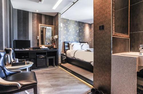 a bedroom with a bed and a desk and a bathroom at W hotel in Incheon