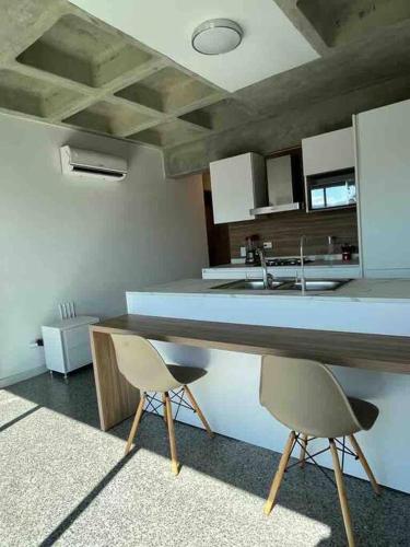 uma cozinha com duas cadeiras e um balcão num quarto em Brand new apt San Bernardino Caracas em Caracas