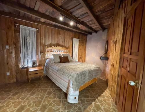 a bedroom with a bed in a wooden room at Cabañas Real Victoria in Tlalpujahua de Rayón