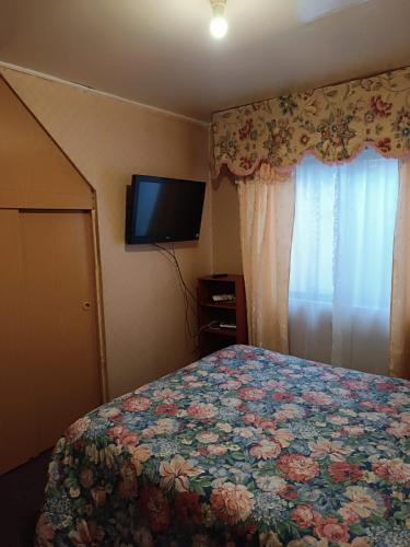 a bedroom with a bed and a tv on the wall at Cómoda Casa en sector residencial Osorno in Osorno