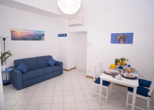 a living room with a blue couch and a table at Fortuna House - De Vivo Realty Sant'Agnello in Sant'Agnello
