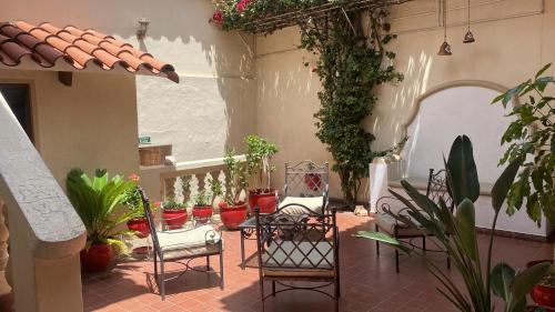um pátio com cadeiras e vasos de plantas em B&B SANTA CECILIA em Sucre