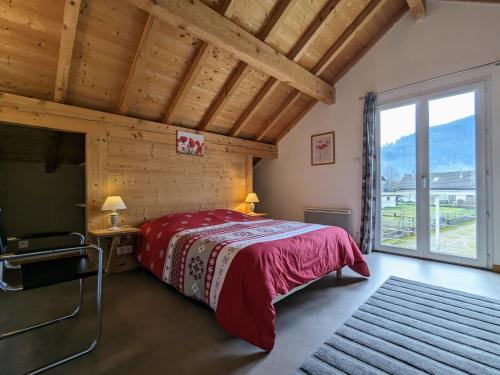 een slaapkamer met een rood bed en een groot raam bij Gîte Saulxures-sur-Moselotte, 4 pièces, 6 personnes - FR-1-589-242 in Saulxures-sur-Moselotte