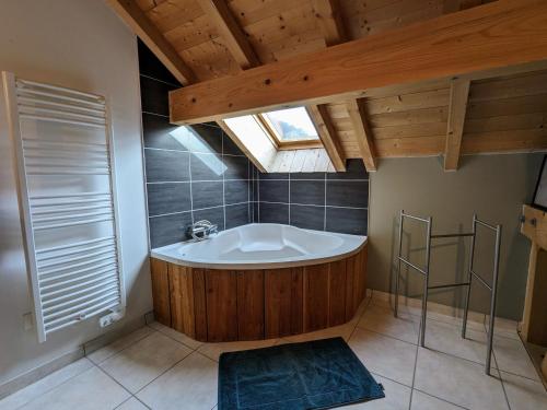 a bathroom with a bath tub and a skylight at Gîte Saulxures-sur-Moselotte, 4 pièces, 6 personnes - FR-1-589-242 in Saulxures-sur-Moselotte