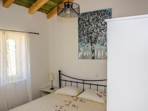 Un dormitorio con una cama y un cuadro en la pared. en Seaside apartments with a swimming pool Razanac, Zadar - 22306, en Ražanac
