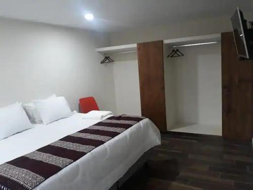 Habitación de hotel con cama y silla roja en El Ciruelo, en Teziutlán