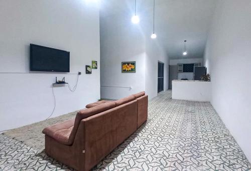 Yolo Hostel في جواو بيسوا: غرفة معيشة مع أريكة وتلفزيون