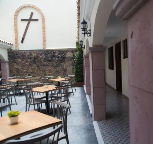 un restaurante con mesas y sillas con una cruz en la pared en El Ciruelo, en Teziutlán