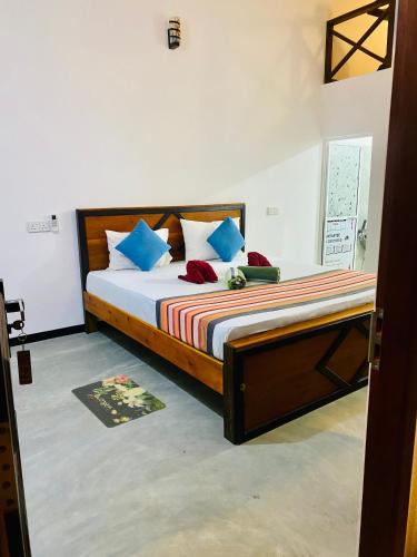 a bedroom with a bed with blue and red pillows at Indika Beach Villa in Galle