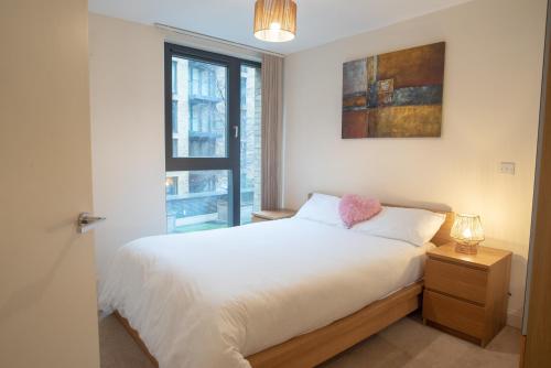 a bedroom with a white bed and a window at Discover Comfort and Style - Your Elegant Stay Offers a 2-Bedroom Haven with Free Parking and Coffee! in Birmingham