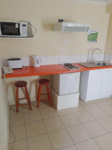 una cucina con bancone, lavandino e forno a microonde di Apart Hotel Melipilla a Melipilla