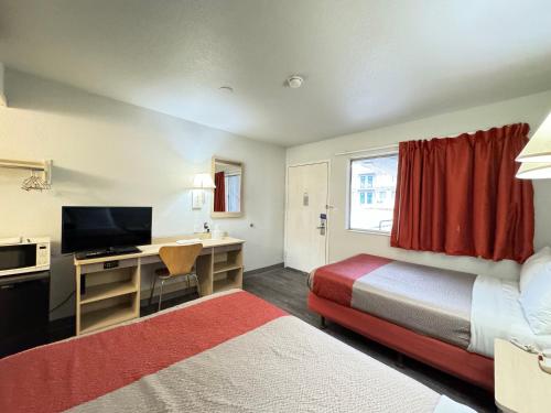 Cette chambre comprend deux lits et un bureau avec une télévision. dans l'établissement Motel 6-Casper, WY, à Casper