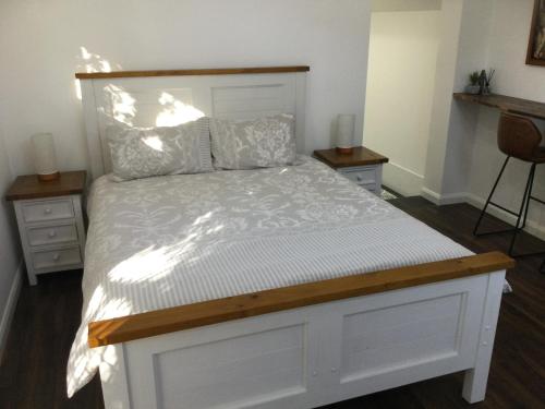 1 dormitorio con 1 cama blanca y 2 mesitas de noche en Studio on Denne, en Tamworth