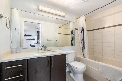 La salle de bains est pourvue d'un lavabo, de toilettes et d'une baignoire. dans l'établissement Downtown 1 Bedroom Water View Condo, à Vancouver