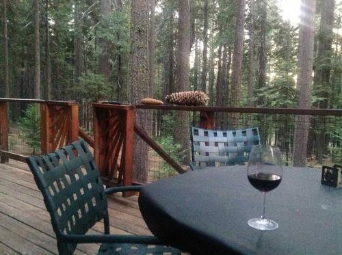a glass of wine sitting on a table on a deck at Sweet Retreat: Theater, Pool/Ping-Pong, Quiet! in Camp Connell