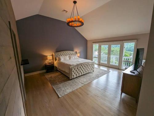 una grande camera da letto con un letto e un lampadario a braccio di Candlewood Lake -Family Getaway, Lakefront 3775 sqft Home a Danbury