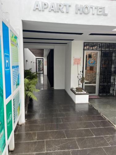 una entrada a un hotel del aeropuerto con suelo de baldosa en Apart Hotel Melipilla, en Melipilla