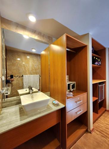 a bathroom with a sink and a microwave at El Mariscal Cusco in Cusco