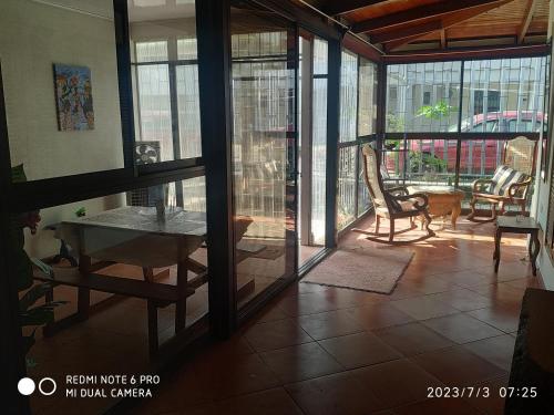 a living room with glass doors and a table and chairs at Villa Zurí in Guanacaste