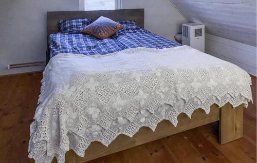 a bed with a blue and white comforter on it at 1 Bedroom Beautiful Home In Glemmingebro in Löderup