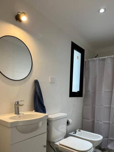 uma casa de banho com um WC, um lavatório e um espelho. em 57 entre 24 y 25, La Plata. Alquiler temporario. em La Plata