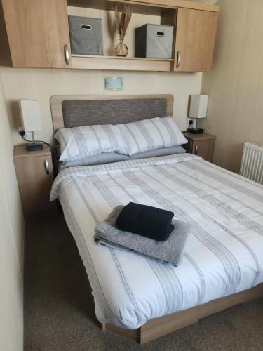 a bedroom with a bed with a black pillow on it at Swn y Mor (Glamorgan 23) in New Quay