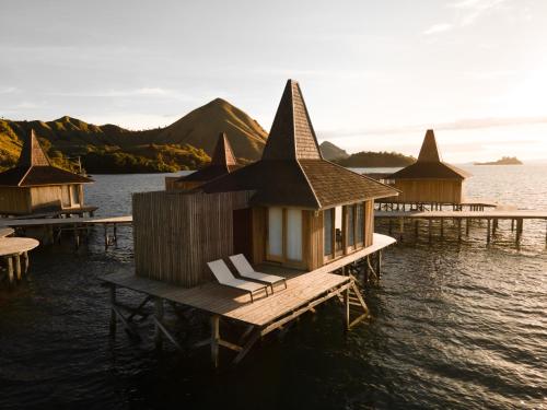 a group of houses on a dock in the water at Menjaga Bay in Labuan Bajo