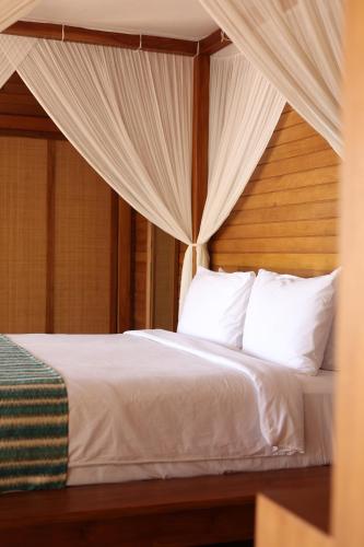 a bedroom with a bed with white sheets and pillows at Menjaga Bay in Labuan Bajo