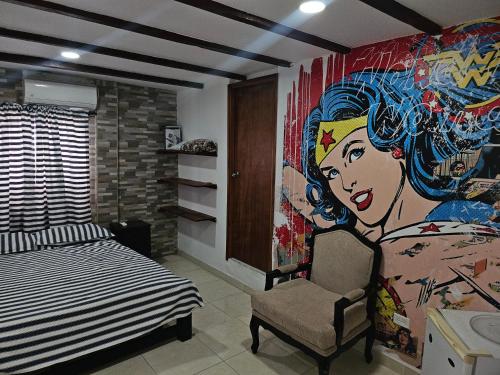 1 dormitorio con una gran pintura en la pared en El Hostal By Pochet, en San Andrés
