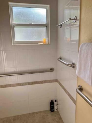 a white bathroom with a shower and a window at 3 SUITES AT BLUE PAVILION - 3 Apartments, 3 Kitchens - Steps to BEACH in West Bay