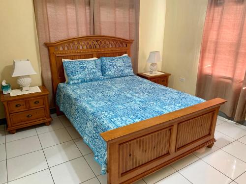 a bedroom with a wooden bed with a blue comforter at 3 SUITES AT BLUE PAVILION - 3 Apartments, 3 Kitchens - Steps to BEACH in West Bay