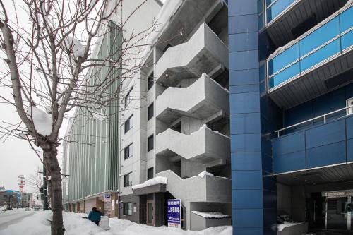 a building with snow on the side of it at ASTRAL【2min from Asahikawa sta】 in Asahikawa