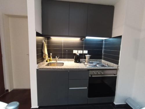 a black kitchen with a sink and a stove at Turismo Apart Palermo in Buenos Aires