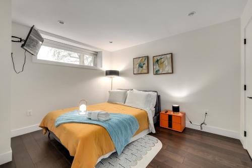 ein Schlafzimmer mit einem Bett mit einer gelben Decke und einem Fenster in der Unterkunft BEB in Vancouver