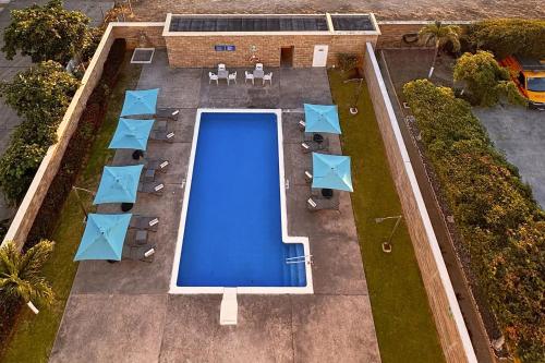 an overhead view of a swimming pool with tables and chairs at City Express by Marriott Manzanillo in Manzanillo
