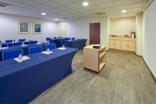 a conference room with blue tables and blue chairs at City Express by Marriott Manzanillo in Manzanillo