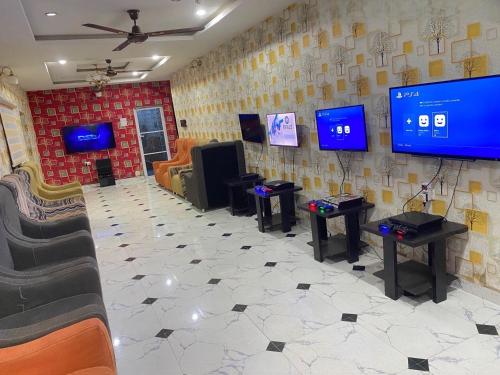 a video game room with four tables and televisions at DIVINE VILLA AND RESORTS HOTEL GUEST House 15 mins Near Michael Okpara University Sam Mbakwe Airport in Umuhu