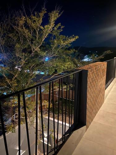 a balcony with a fence and a tree at night at Nossa suíte - Praia da Pipa in Pipa