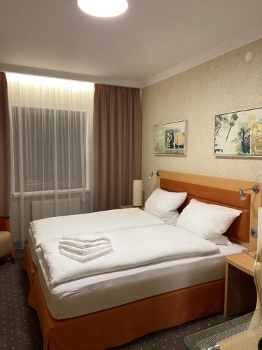 um quarto com uma cama grande e lençóis brancos em Hotel Alter Hof 