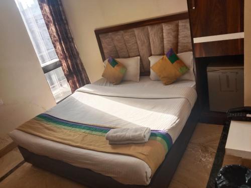 a bedroom with a large bed with pillows at HOTEL MERCURY 50 STEP FROM DARBAR SAHIB in Amritsar