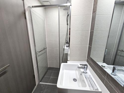 a bathroom with a sink and a shower at 라비앙즈-Raviens-Elliy's Room in Busan