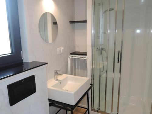 a white bathroom with a sink and a shower at Holiday homes with sauna and jacuzzi in Trz sacz in Trzęsacz